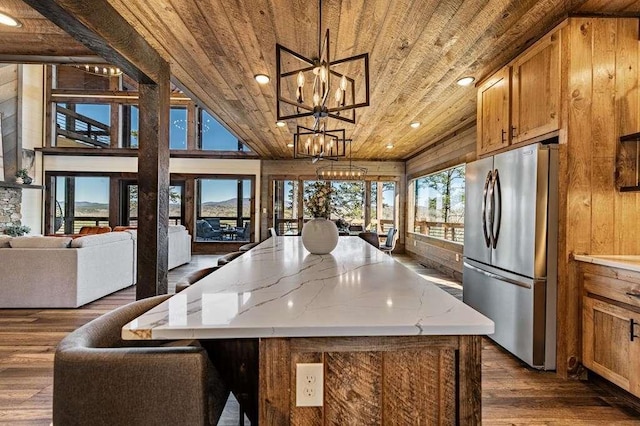 kitchen with a kitchen island, decorative light fixtures, stainless steel fridge, a notable chandelier, and wood ceiling