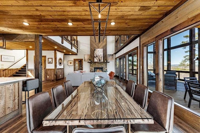 unfurnished dining area featuring a large fireplace, wooden ceiling, dark hardwood / wood-style floors, and a healthy amount of sunlight