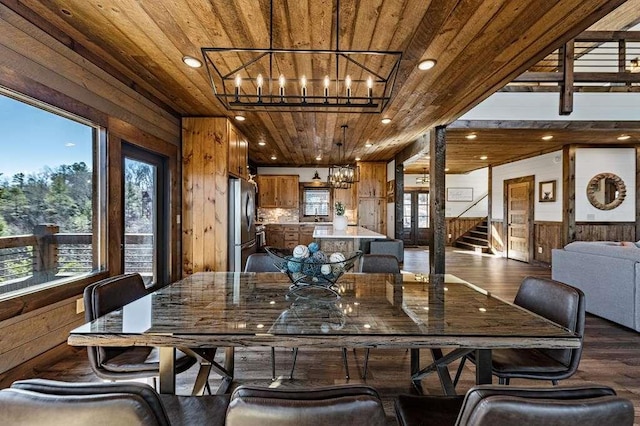 dining area featuring wood ceiling, dark hardwood / wood-style floors, wooden walls, and an inviting chandelier