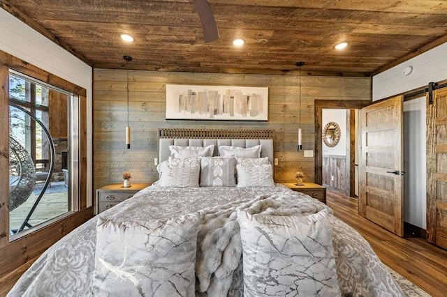 bedroom with wooden walls, wood-type flooring, access to exterior, a barn door, and wooden ceiling