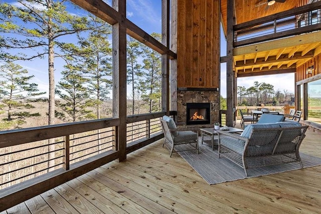 sunroom / solarium with an outdoor stone fireplace