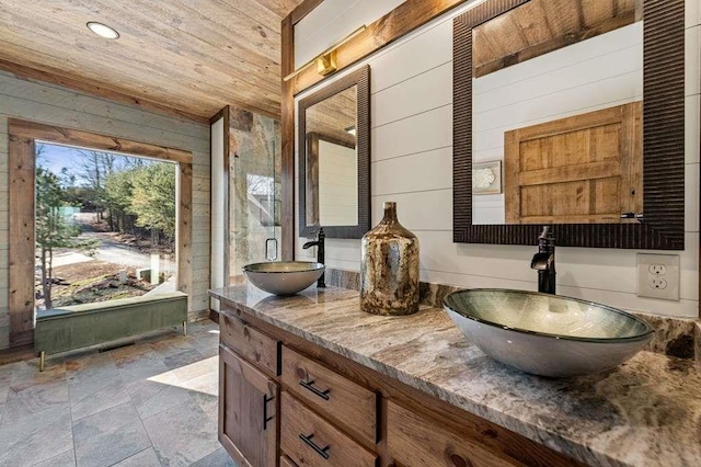 bathroom with wood ceiling, vanity, and wood walls