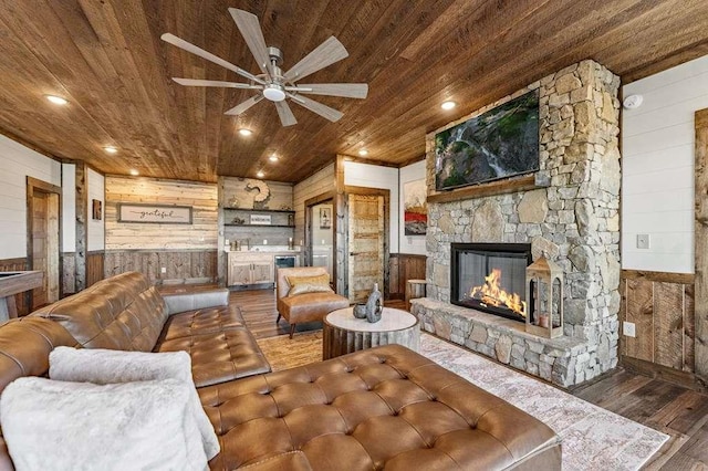 living room featuring hardwood / wood-style floors, a fireplace, wooden ceiling, and wooden walls