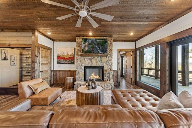 living room featuring wood-type flooring, a fireplace, wood ceiling, and wood walls