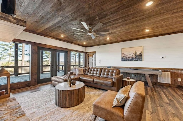 living room with french doors, wood walls, wood ceiling, wood-type flooring, and ceiling fan