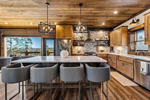 kitchen featuring wall chimney range hood, wood ceiling, sink, stainless steel appliances, and decorative light fixtures