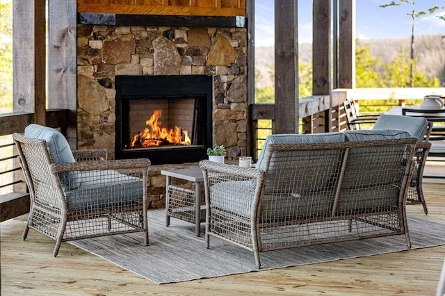 living area with hardwood / wood-style flooring and an outdoor stone fireplace