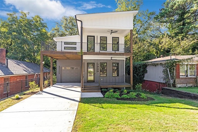 view of front of property featuring ceiling fan, a garage, french doors, a balcony, and a front lawn