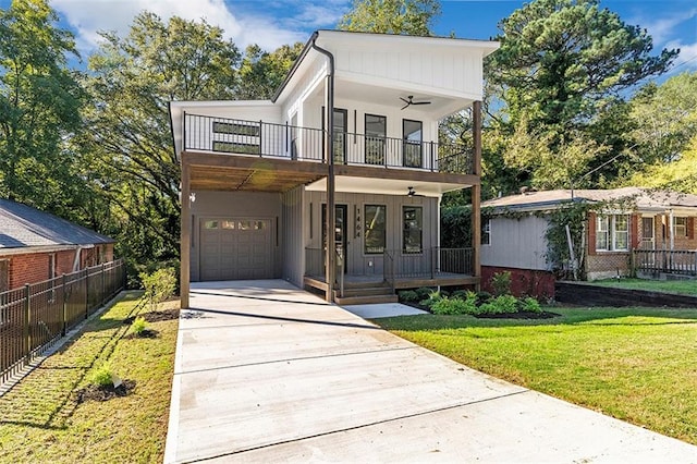 view of front of house featuring a garage, a balcony, a front lawn, and covered porch