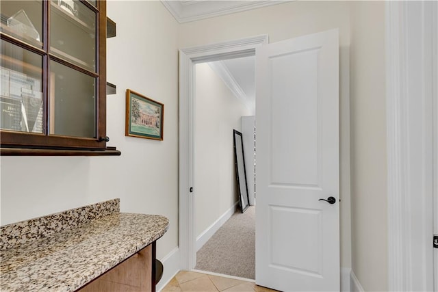 hall featuring ornamental molding and light tile patterned floors