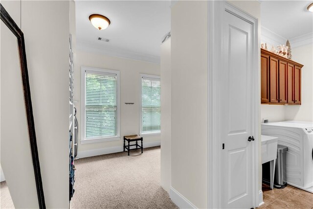 washroom with light carpet, washer / clothes dryer, cabinets, and ornamental molding