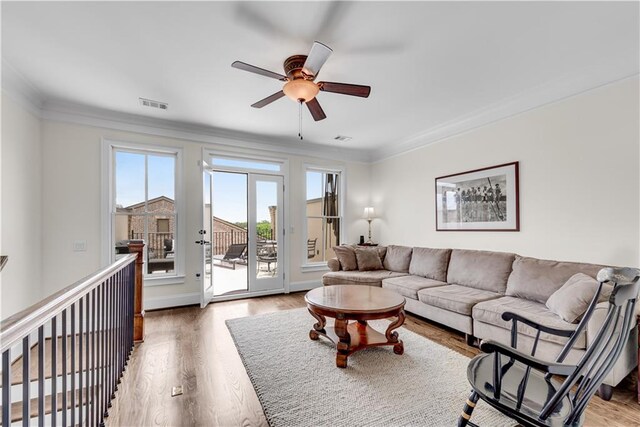 living room featuring hardwood / wood-style floors, crown molding, and ceiling fan