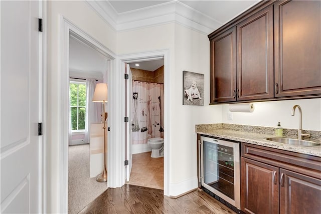 kitchen featuring ornamental molding, hardwood / wood-style floors, sink, and beverage cooler