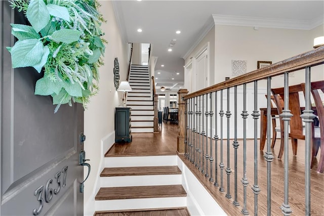 staircase featuring hardwood / wood-style flooring and ornamental molding