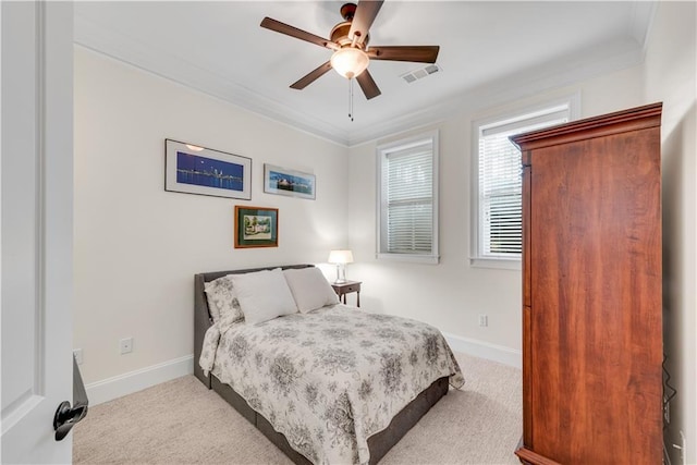 carpeted bedroom with ornamental molding and ceiling fan