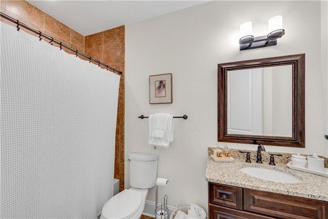 full bathroom with vanity, shower / bath combo, and toilet