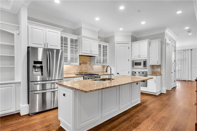 kitchen featuring white cabinetry, stainless steel appliances, dark wood-type flooring, and a center island with sink