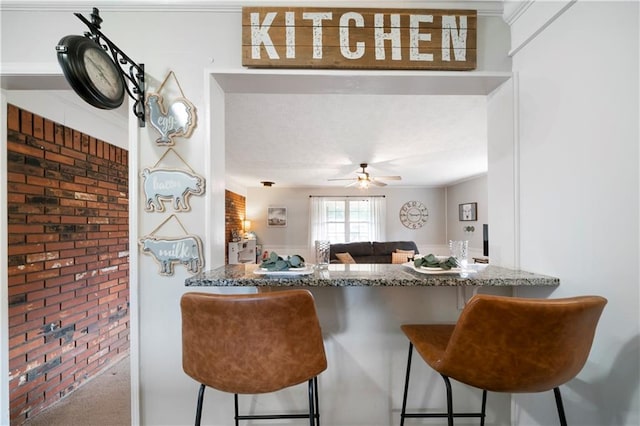 kitchen with carpet floors, brick wall, and kitchen peninsula