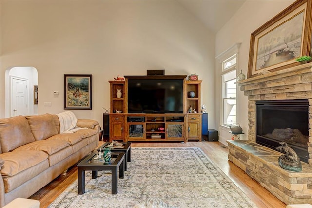 103 Old Avery Dr, Canton, GA 30115 - living area featuring light wood-type flooring, arched walkways, a stone fireplace, and high vaulted ceiling