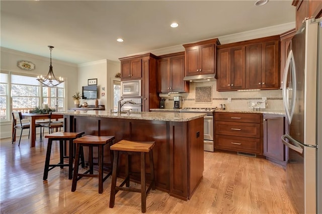 103 Old Avery Dr, Canton, GA 30115 - kitchen featuring appliances with stainless steel finishes, under cabinet range hood, crown molding, tasteful backsplash, and light wood finished floors