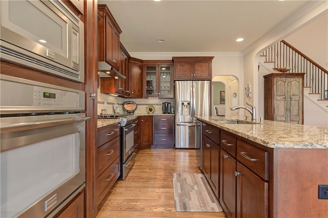 103 Old Avery Dr, Canton, GA 30115 - kitchen featuring appliances with stainless steel finishes, a sink, light wood-style floors, glass insert cabinets, and arched walkways