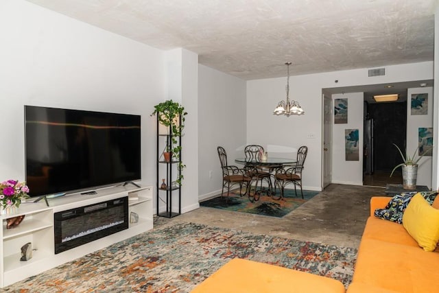 living room with concrete floors and a notable chandelier