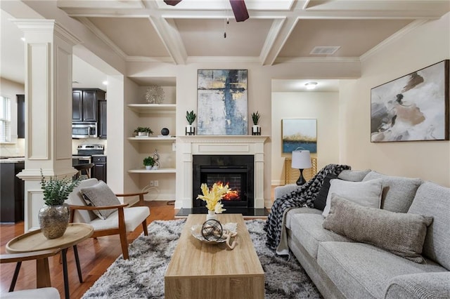 living room featuring hardwood / wood-style flooring, decorative columns, and coffered ceiling