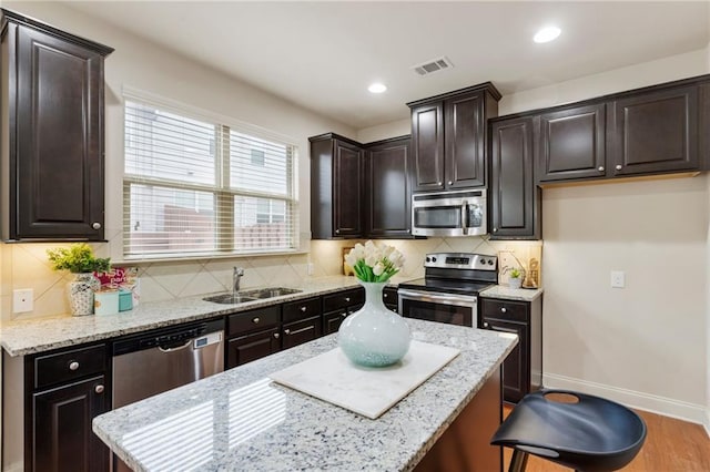 kitchen with hardwood / wood-style flooring, backsplash, sink, and appliances with stainless steel finishes