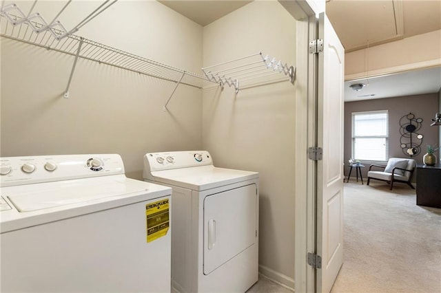 clothes washing area with light carpet and washer and clothes dryer