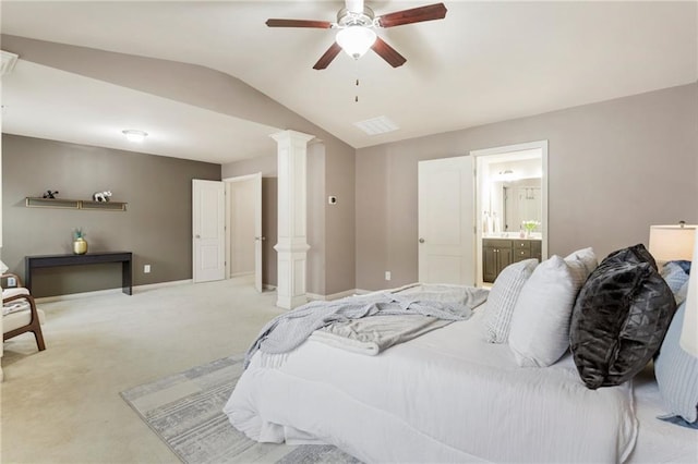 carpeted bedroom featuring decorative columns, connected bathroom, ceiling fan, and vaulted ceiling