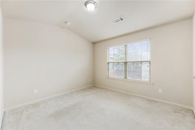 empty room with light carpet and vaulted ceiling