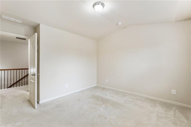 carpeted spare room with lofted ceiling