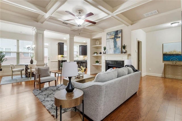 living room featuring ceiling fan, coffered ceiling, built in features, beamed ceiling, and hardwood / wood-style floors