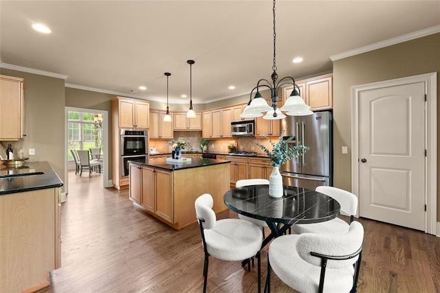 kitchen with light brown cabinetry, dark wood-style flooring, dark countertops, and appliances with stainless steel finishes