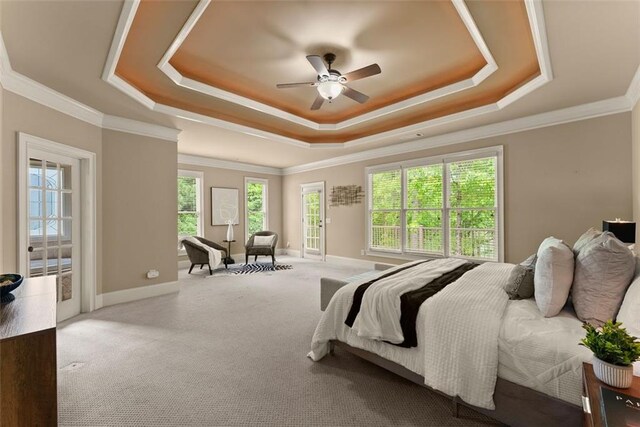 carpeted bedroom featuring a ceiling fan, access to exterior, crown molding, baseboards, and a tray ceiling