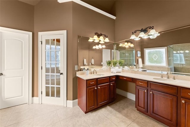 full bath with a sink, tile patterned floors, baseboards, and double vanity
