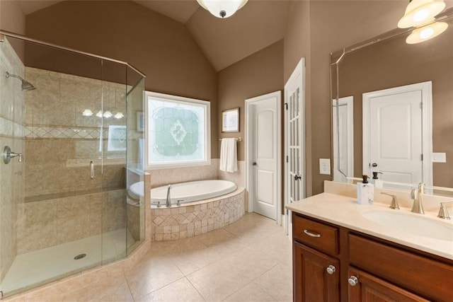 bathroom featuring vaulted ceiling, tile patterned floors, a stall shower, and a garden tub