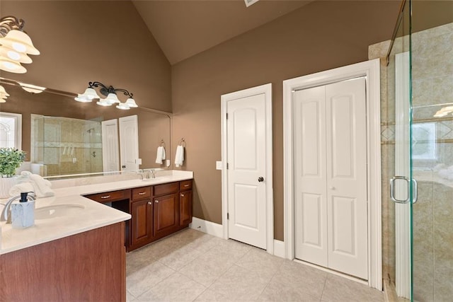 bathroom with high vaulted ceiling, a shower stall, tile patterned flooring, and vanity