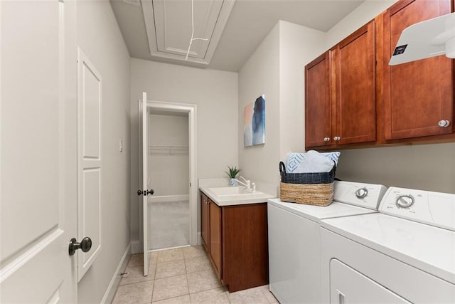 laundry room featuring washing machine and dryer, light tile patterned flooring, attic access, a sink, and cabinet space