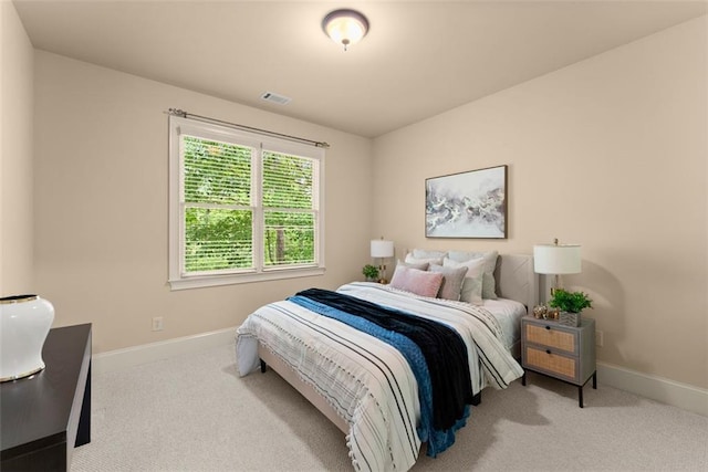 carpeted bedroom featuring baseboards and visible vents