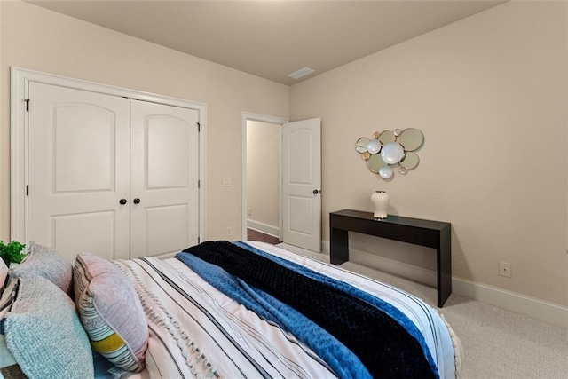 bedroom featuring baseboards, visible vents, carpet, and a closet