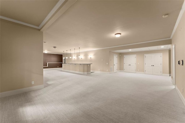 unfurnished living room with baseboards, ornamental molding, and light colored carpet