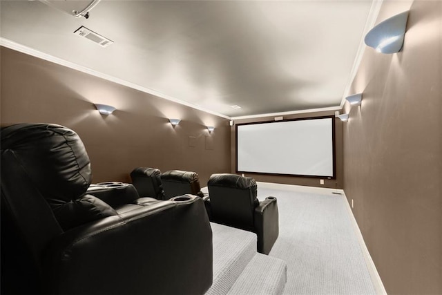 home theater room with carpet floors, crown molding, visible vents, and baseboards
