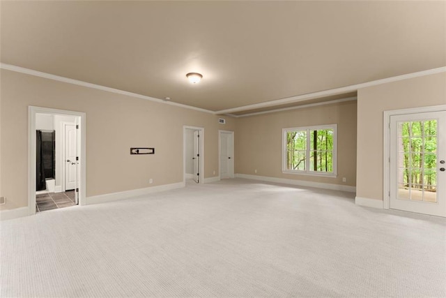 empty room with crown molding, light carpet, and a wealth of natural light