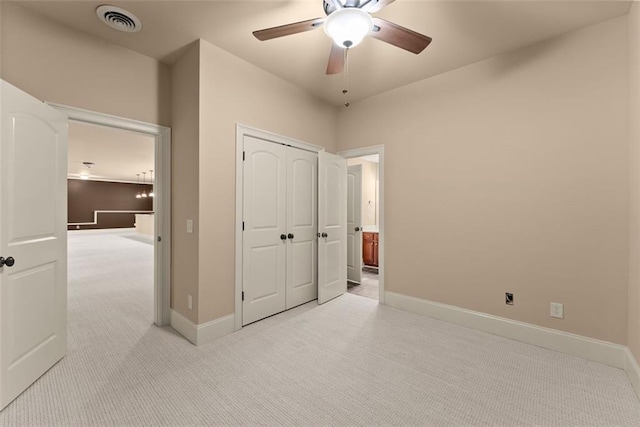 unfurnished bedroom featuring light colored carpet, baseboards, visible vents, and a closet