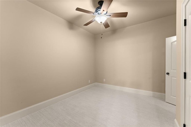 spare room with baseboards, light carpet, and a ceiling fan