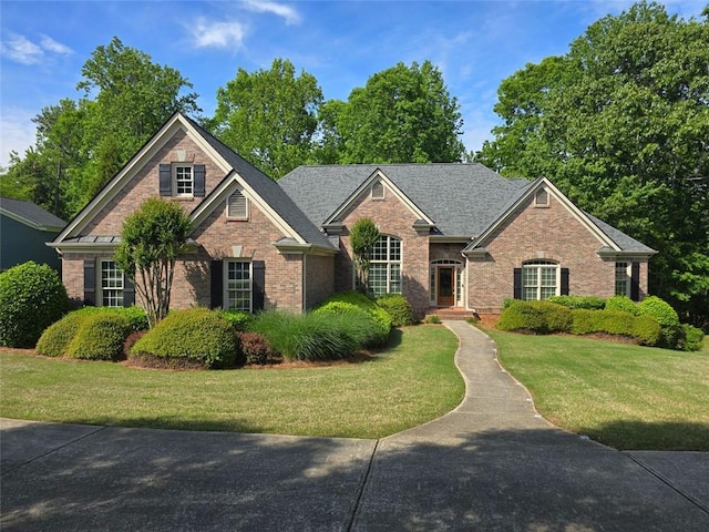view of front facade featuring brick siding and a front lawn