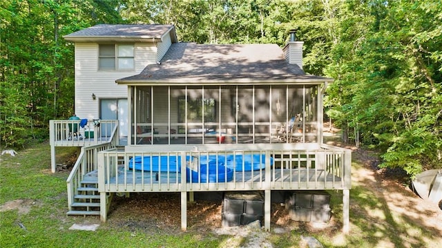 rear view of house with a wooden deck and a sunroom