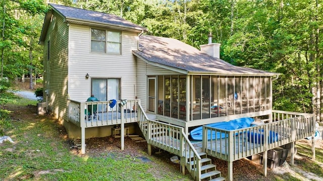 back of property featuring a sunroom and a deck