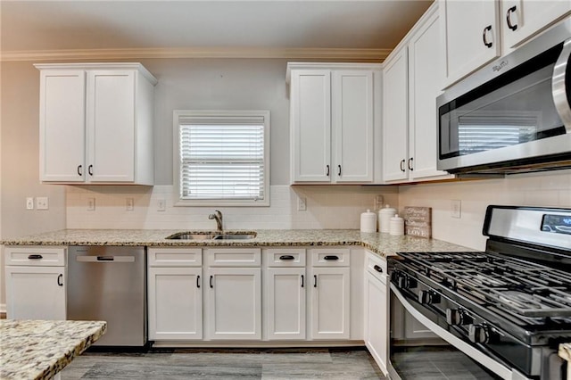 kitchen with sink, backsplash, stainless steel appliances, and white cabinets